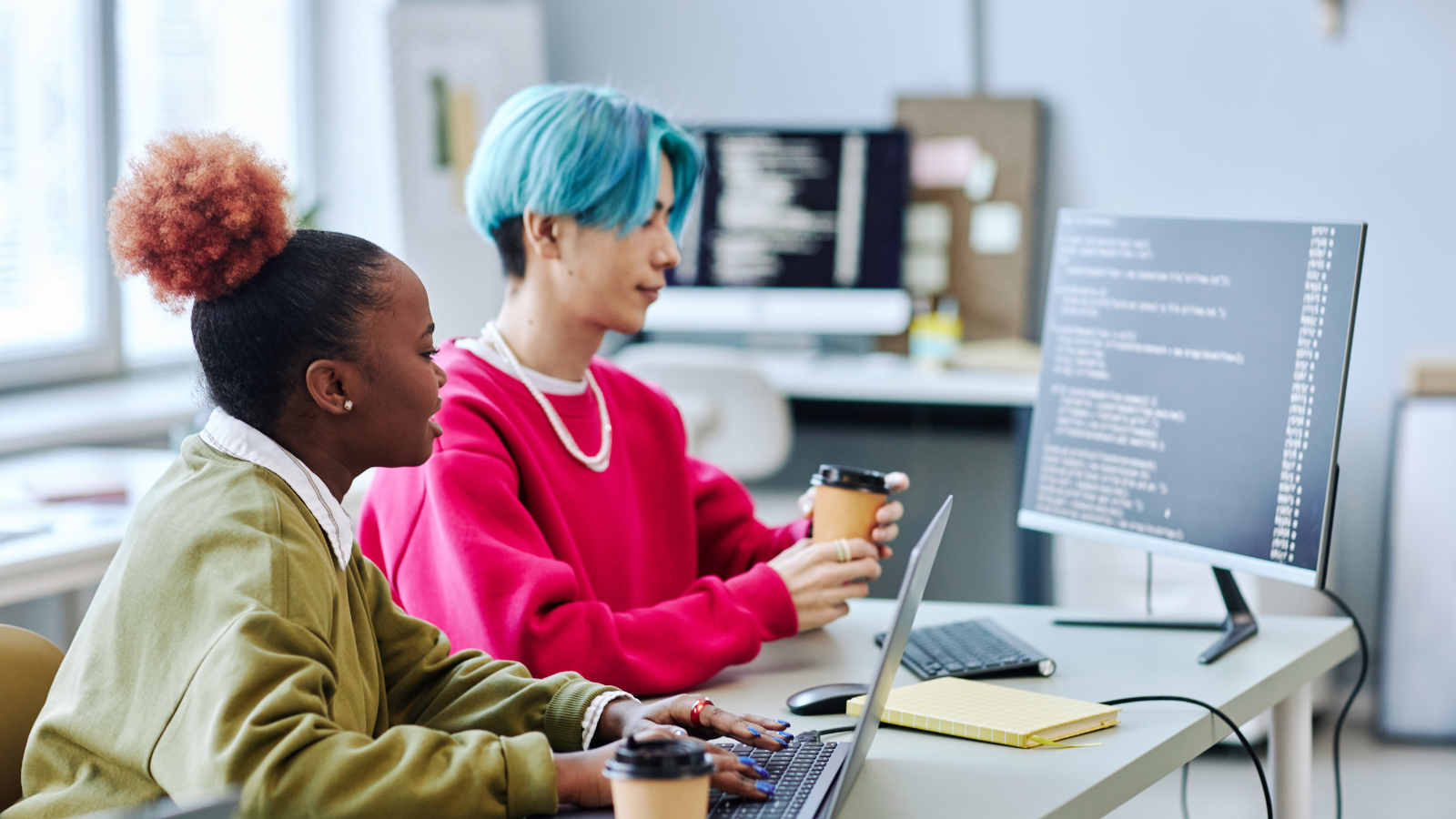 two gen z workers looking at screen